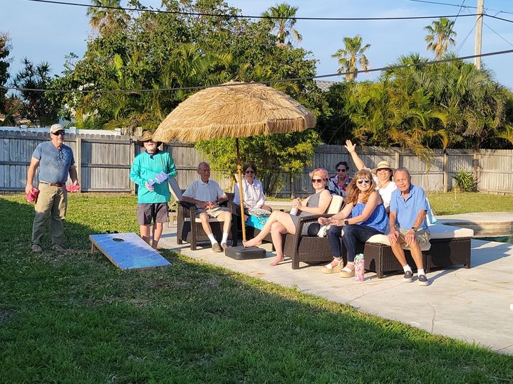 Family in a backyard playing cornhole